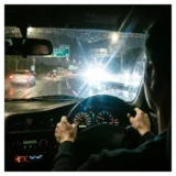 夜間運転中に対向車のヘッドライトの眩しさに悩む運転者の視点