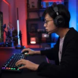 ゲーミングデスクで眼鏡をかけてモニターを見る人物のイラスト。ゲーム中の眼精疲労と両眼視機能検査の重要性を表現